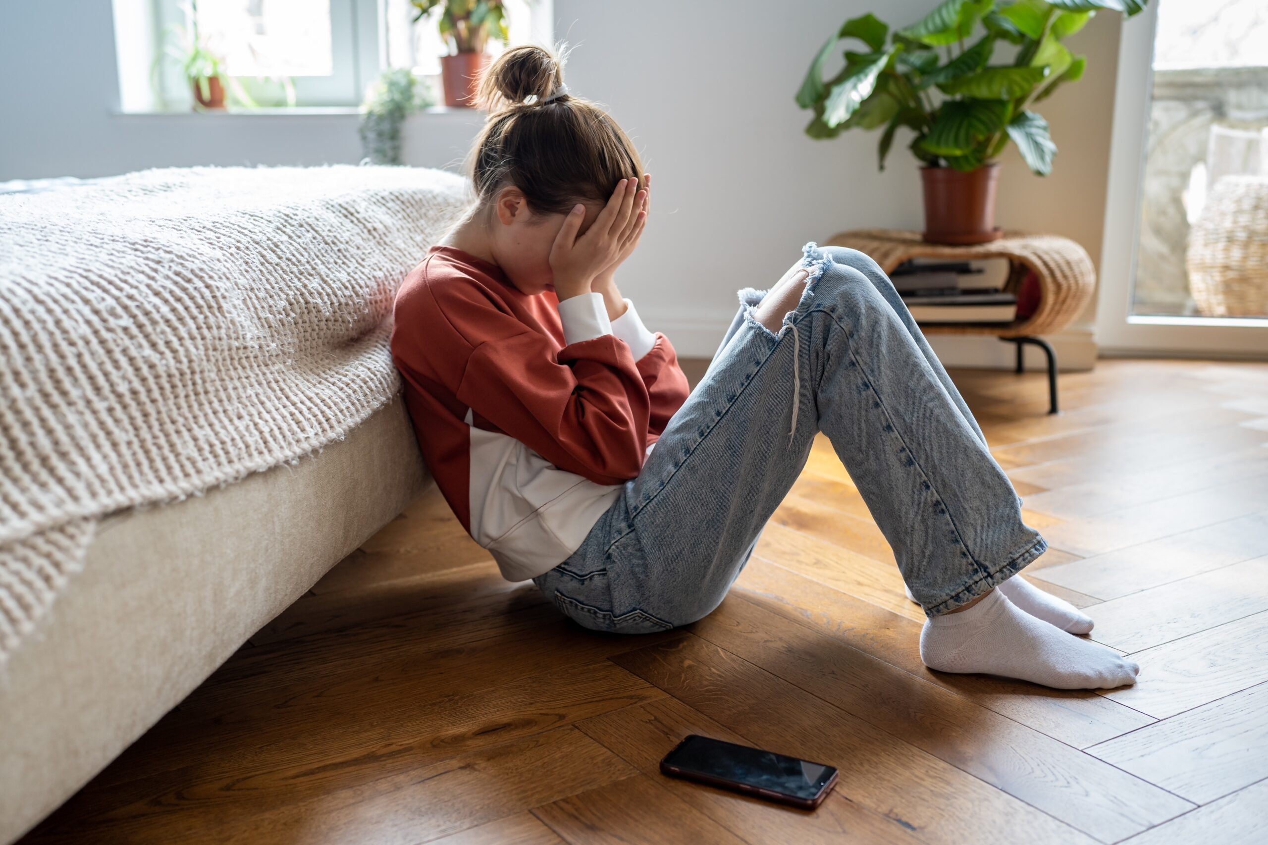 A child experiences anxiety and covers her face.